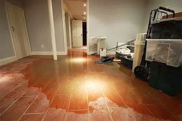 Standing water across the tile floor of a flooded finished basement in Monroe Township